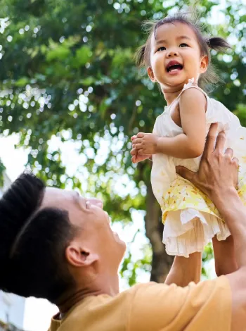 Lifestyle image of father holding their baby daughter