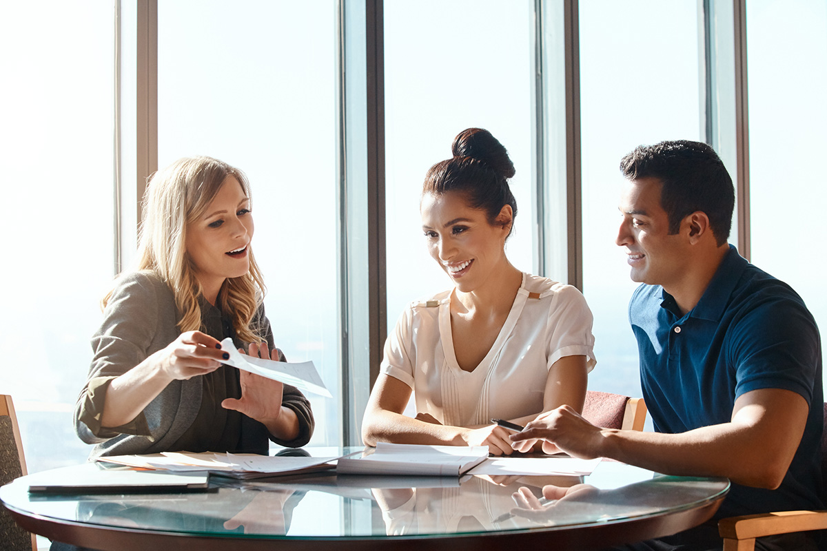 Shot of a young couple meeting with a financial planner mortgage professional in a modern office