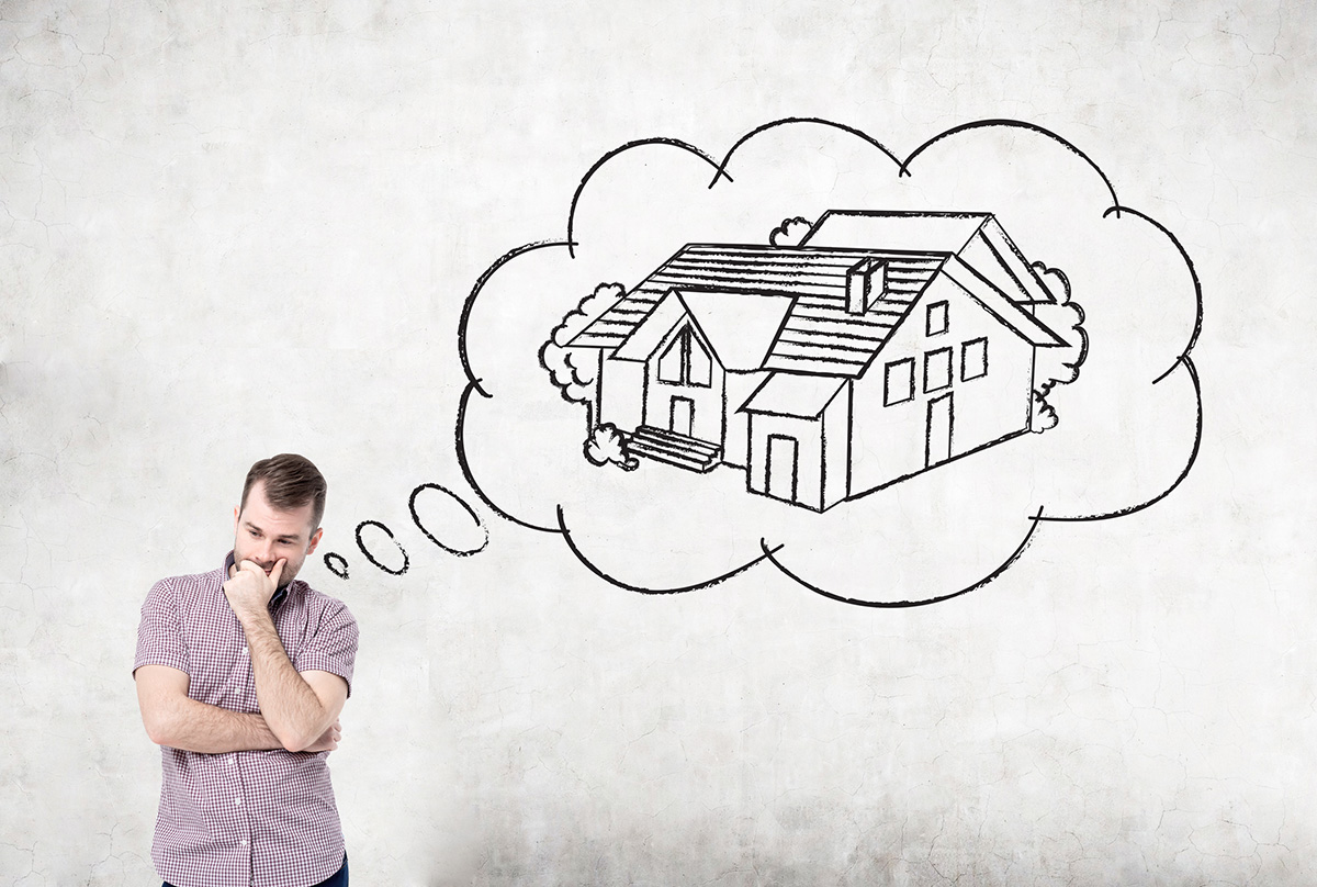 Pensive casual young man daydreaming about buying a house on concrete background. Concept of mortgage and real estate