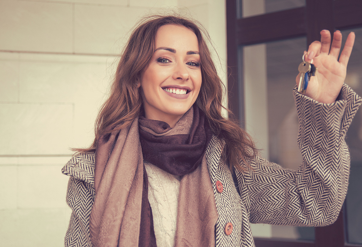 Happy beautiful woman holding keys from her new apartment