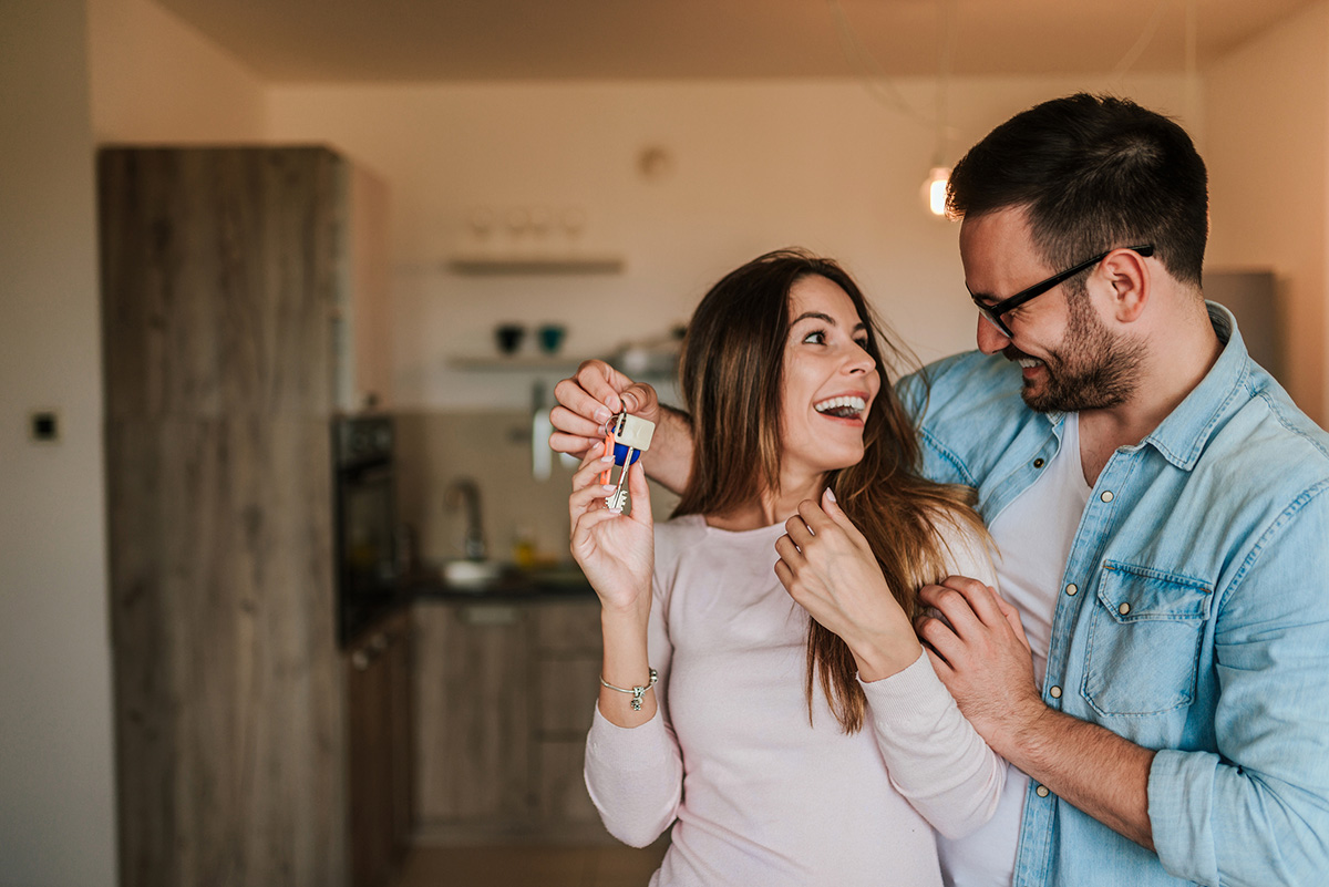 Young man surprising his wife or a girl with new a apartment.